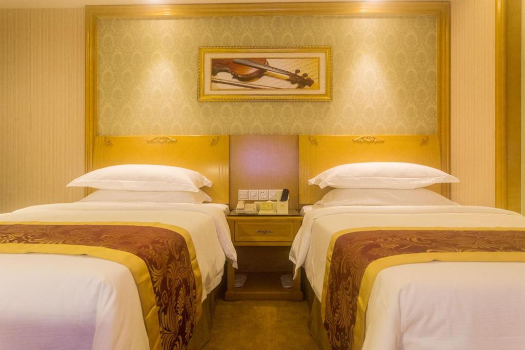 三亚维也纳酒店海南三亚亚龙湾千古情店的酒店客房,设有两张床和镜子