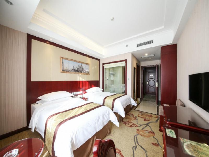 上海维也纳酒店上海虹桥会展中心店的酒店客房设有四张床和平面电视。