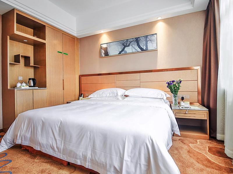武汉维也纳国际酒店武汉街道口店的卧室配有一张白色大床