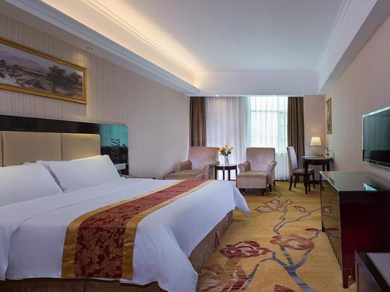 西乡维也纳酒店深圳宝安流塘店的酒店客房设有一张大床和一间客厅。