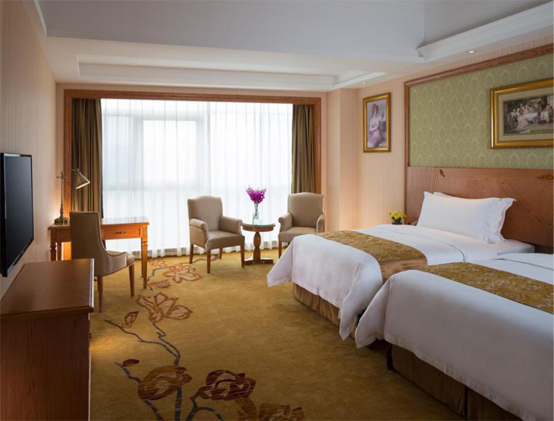 龙岗维也纳国际酒店深圳龙岗李朗店的酒店客房配有两张床和一张书桌