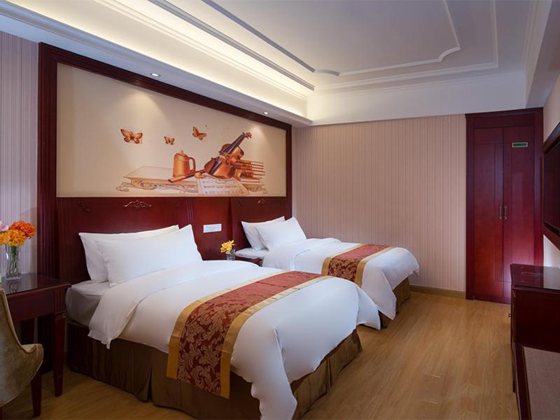 深圳维也纳酒店深圳会展中心二店的酒店客房设有两张床,墙上挂有绘画作品