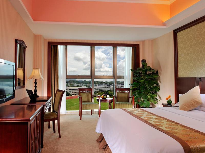 深圳维也纳酒店大学城店的一间卧室配有一张床、一张书桌和一台电视