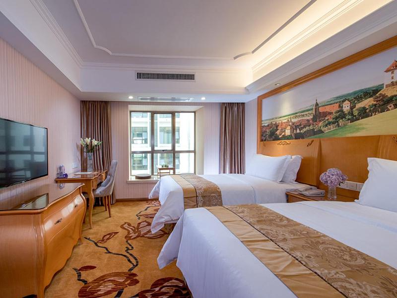 南宁维也纳酒店广西南宁高新区店的酒店客房设有两张床和一台平面电视。