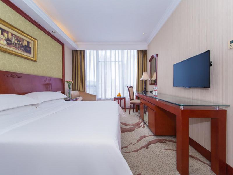 襄阳维也纳酒店襄阳火车站店的酒店客房配有一张床和一张书桌及一台电视