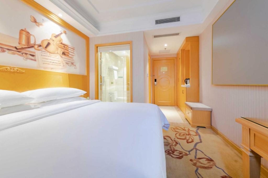 深圳维也纳3好酒店深圳西丽南科大店的卧室配有白色的床和电视。