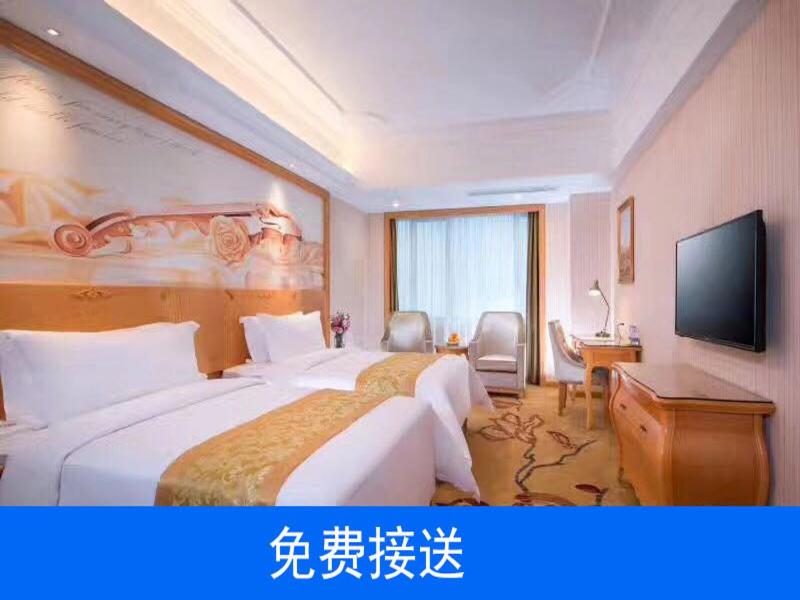 广州维也纳酒店广州番禺南站店的酒店客房设有两张床和一台平面电视。