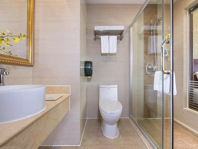 龙岗维也纳酒店深圳龙岗龙东店的一间带卫生间和玻璃淋浴间的浴室