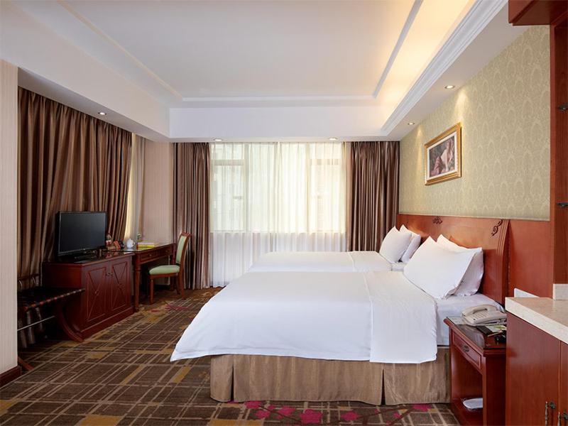 东莞维也纳酒店东莞厚街万达广场店的酒店客房设有一张大床和一台电视。