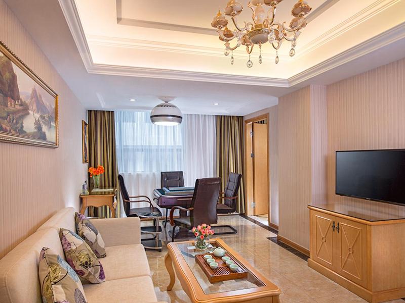 宝安维也纳酒店深圳福永地铁站店的客厅配有沙发和桌子