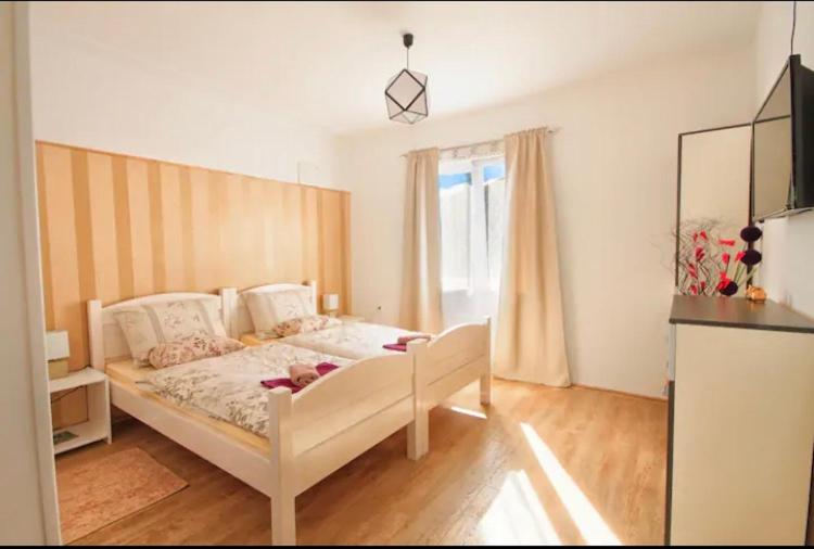 Ličko Petrovo SeloRooms Bobic的卧室配有白色的床和窗户。