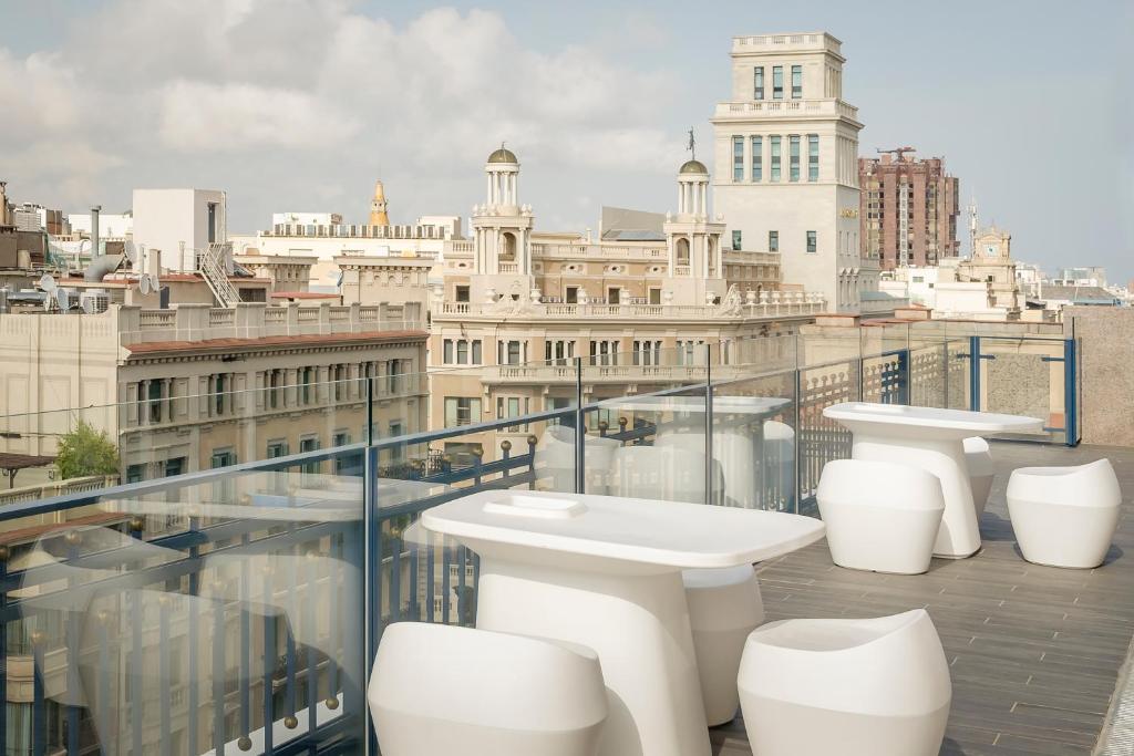 巴塞罗那加泰罗尼亚伊克斯普拉扎酒店的大楼内带水槽和卫生间的阳台