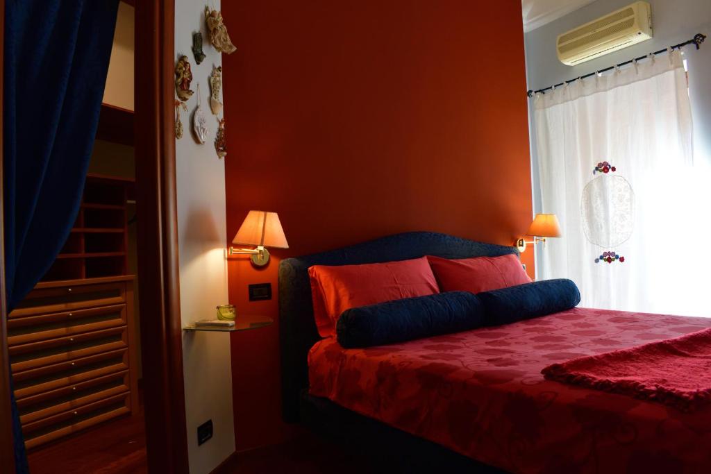 阿格里真托B&B Le Casette Di Lù的一间卧室拥有橙色的墙壁,床上铺有红色床单。