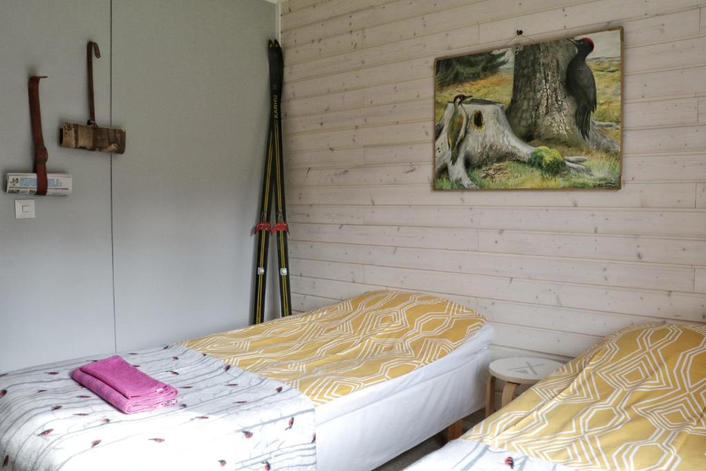 阿卡斯洛姆波罗TaloYlläs, Huonemajoitus的一间卧室设有两张床,墙上挂着一幅画