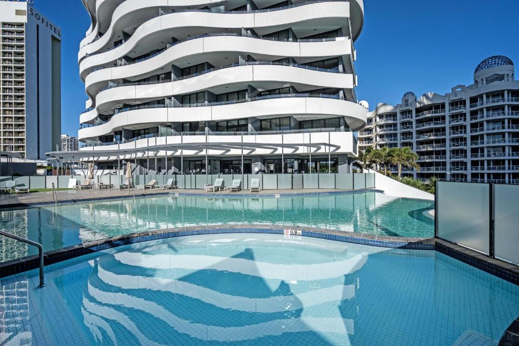 黄金海岸海浪度假酒店的建筑前的一座带游泳池的建筑