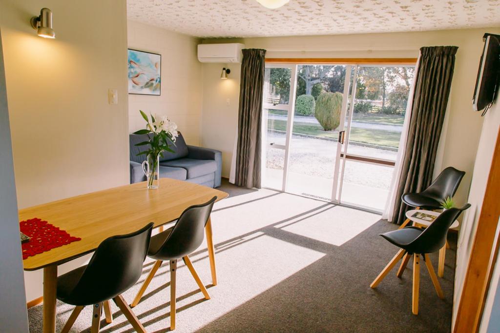 WardFlaxbourne Motels的客厅设有餐桌和椅子