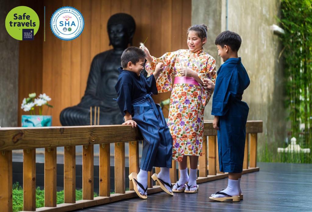 慕斯考艾禅别墅的一名妇女和两名儿童站在雕像旁边