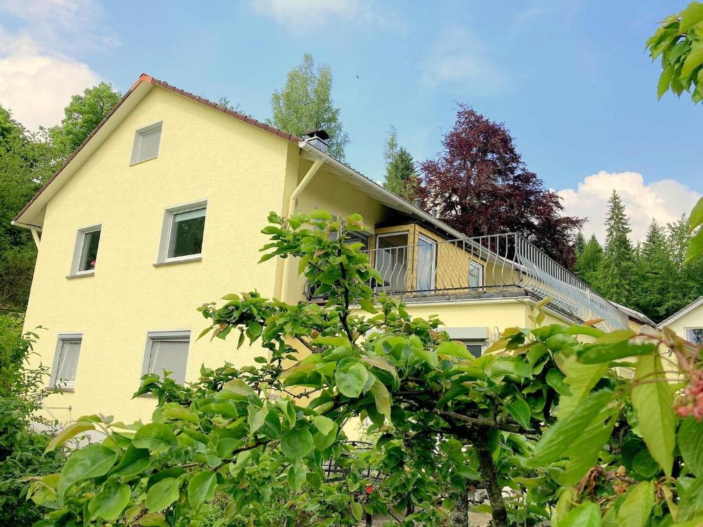 黑林山区克尼格斯费尔德Ferienwohnung am Hörnle的黄色房子的顶部设有阳台