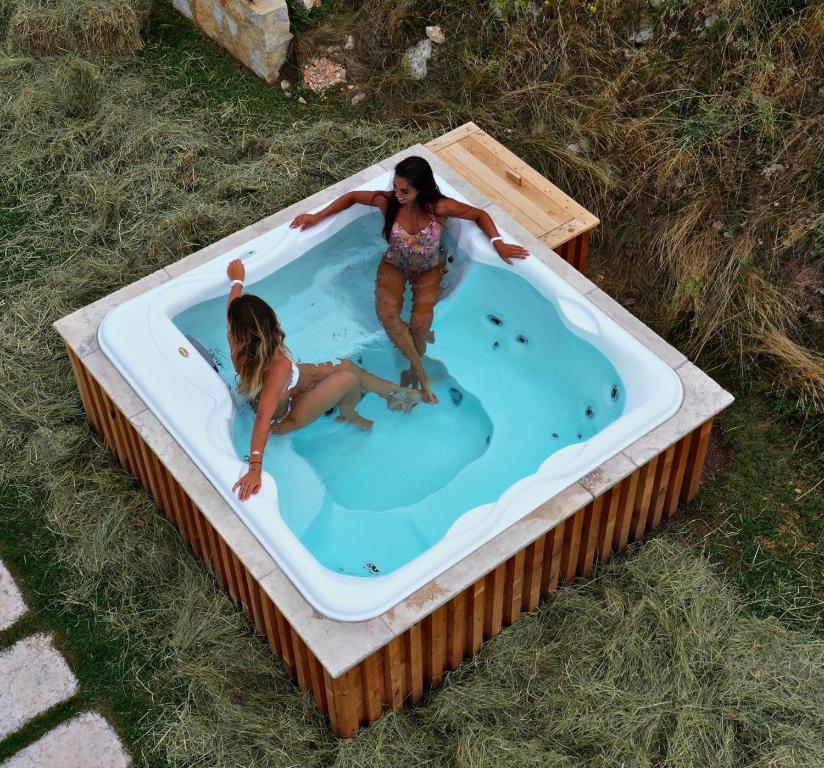 格雷扎纳Ca' del Moro Wine Retreat的两个女孩在草地上的热水浴缸中