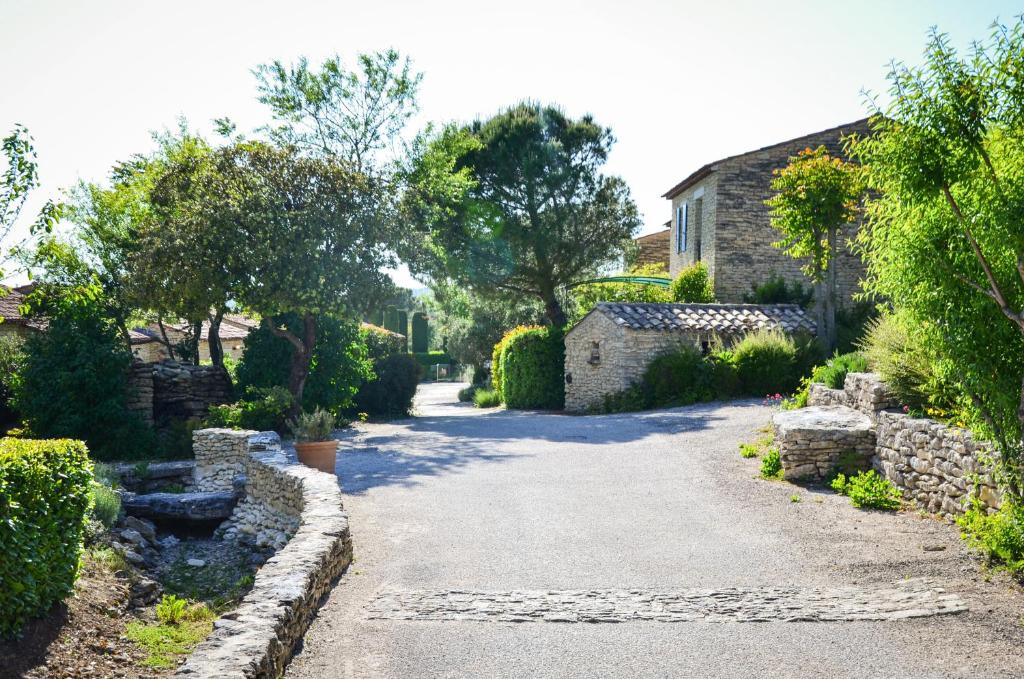 戈尔德Cigale de Gordes的花园内的车道,花园内有石头建筑和树木