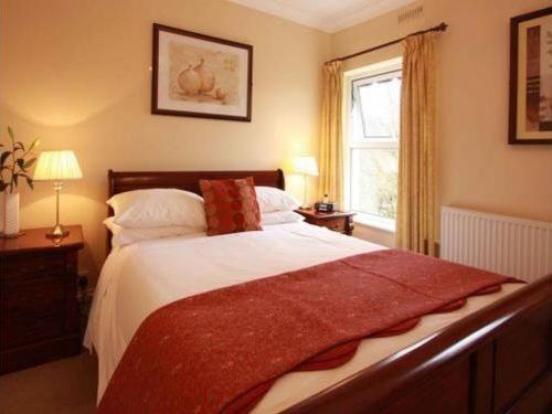 哈罗盖特美利楼酒店的一间卧室设有一张大床和一个窗户。