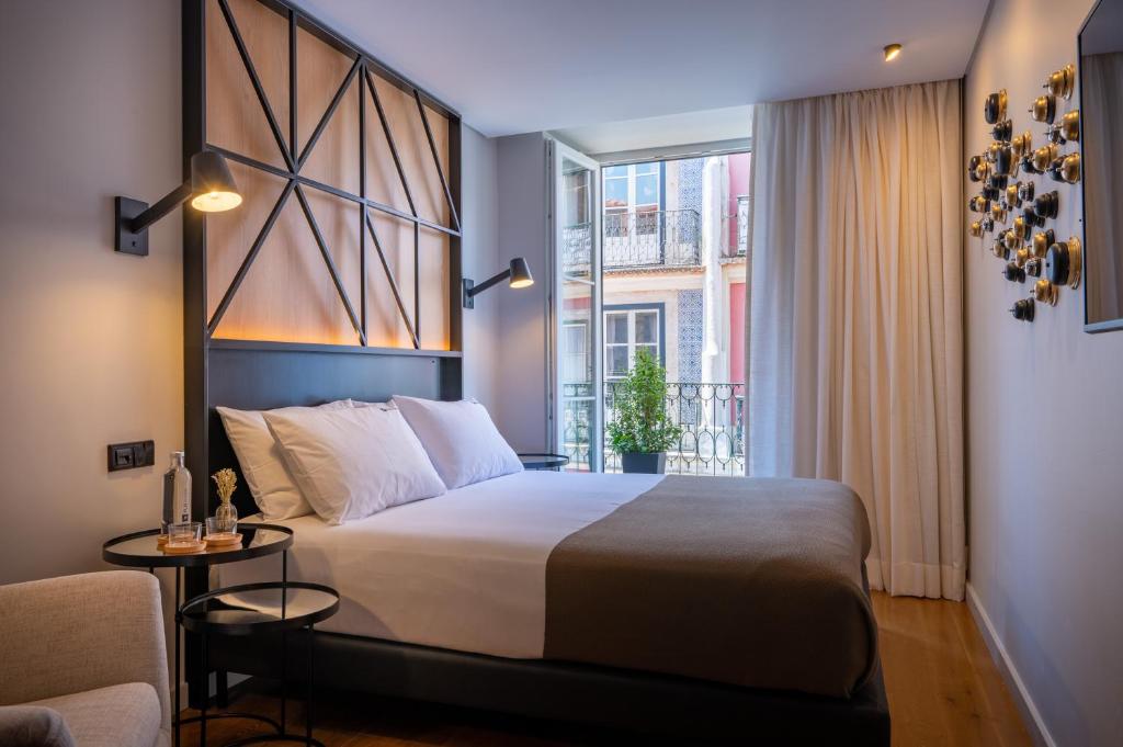 里斯本Ferraria XVI FLH Hotels Lisboa的一间卧室设有一张大床和一个窗户。