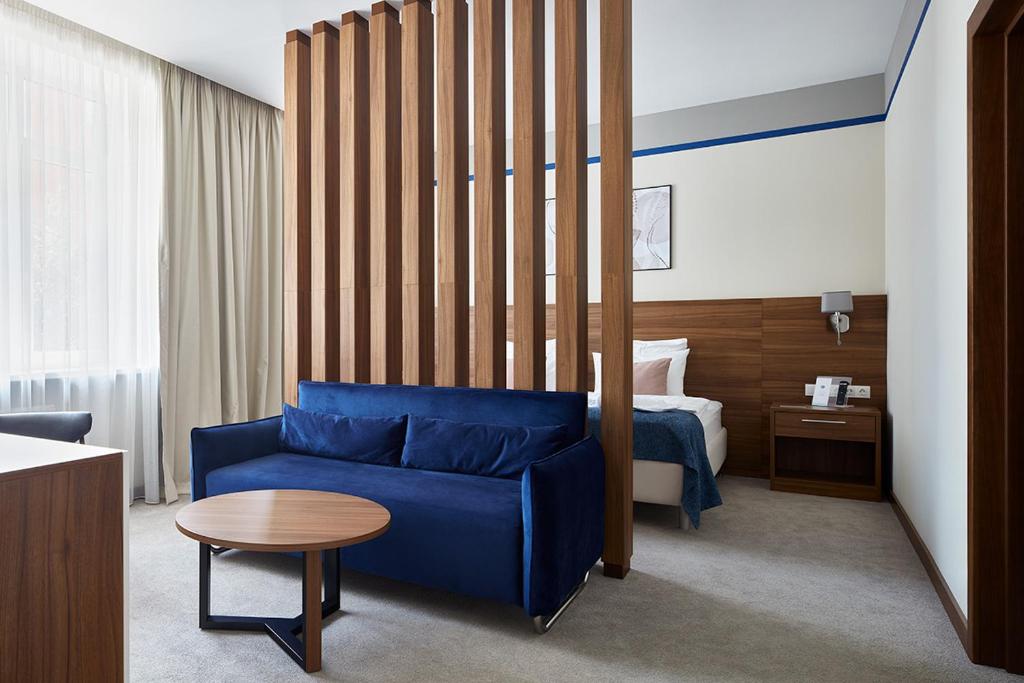 莫斯科Select Hotel Paveletskaya的酒店客房配有蓝色的沙发和床。