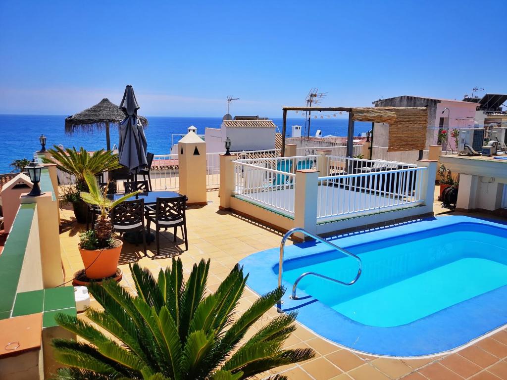 内尔哈卡拉贝奥普拉亚别墅酒店的一座位于一座建筑顶部的游泳池,其背景是大海
