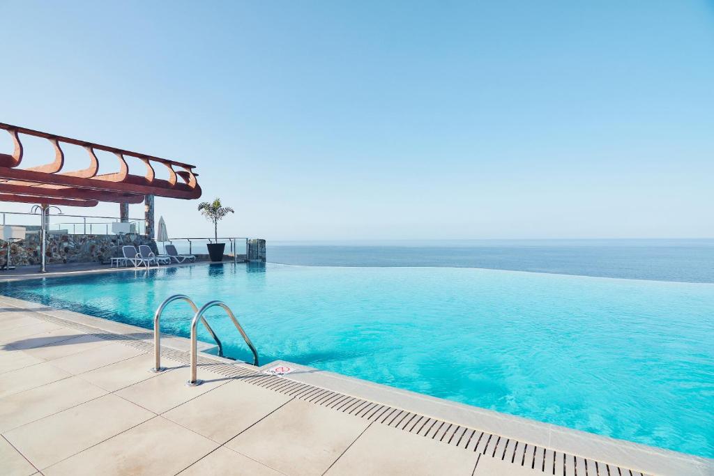 波多黎各凯莱宫阿马多雷斯塔拉索酒店的一个大型的游泳池,背景是大海