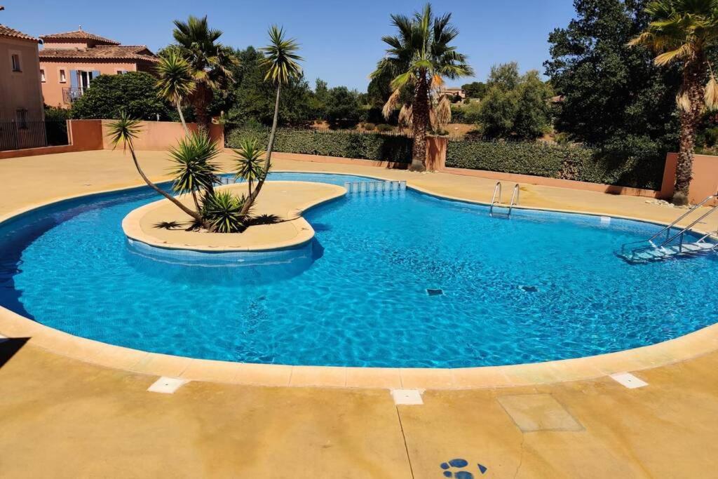 贝济耶Appartement Golf Saint Thomas - Belle résidence的一座种植了棕榈树的大型蓝色游泳池