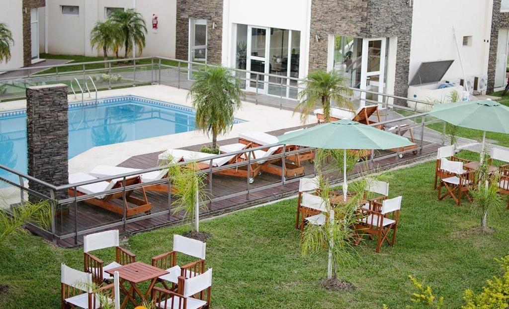 费德拉西翁Altos de Alem的游泳池旁带桌子和遮阳伞的天井