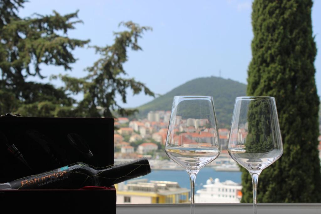 杜布罗夫尼克Aquamarine Deluxe Apartment的两杯酒杯坐在桌子上,享有城市美景