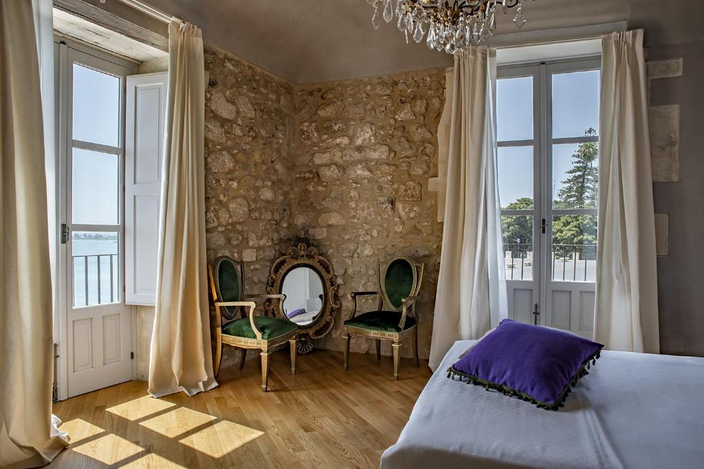 锡拉库扎Dimora Aretusa Luxury的一间卧室配有床、椅子和镜子