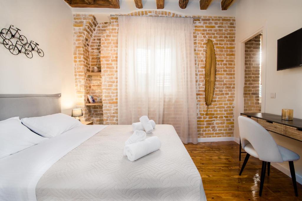 科孚镇Curcumelli Luxury Suites - ΚΟΡΚΥΡΑ的卧室配有一张白色大床和一张书桌