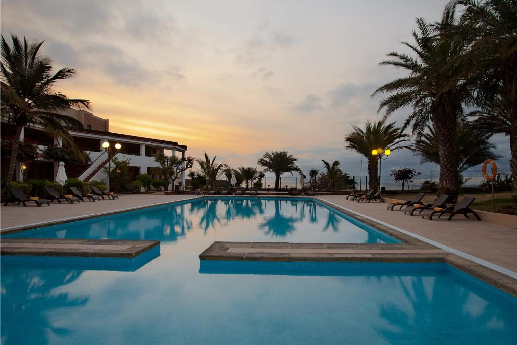 普拉亚Pestana Tropico Ocean & City Hotel的一座享有日落美景的游泳池