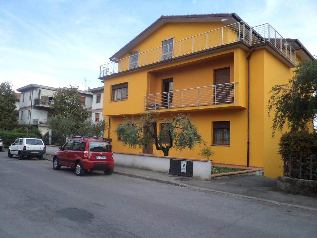 皮斯托亚Irene的一座黄色的建筑,前面有汽车停放