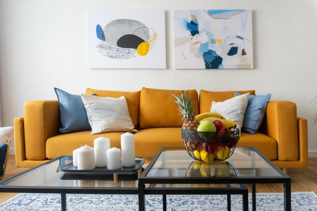 贝尔格莱德Akiton Apartment的客厅配有沙发和带一碗水果的桌子