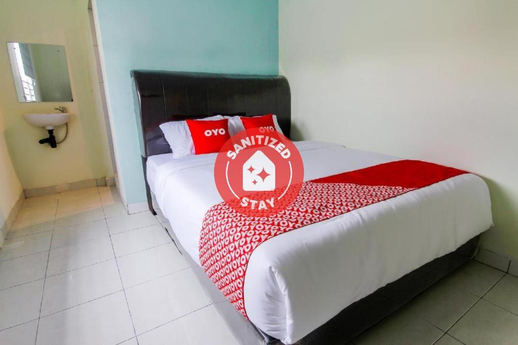 棉兰SUPER OYO 3493 Nami House的一间卧室配有一张带红白毯子的床