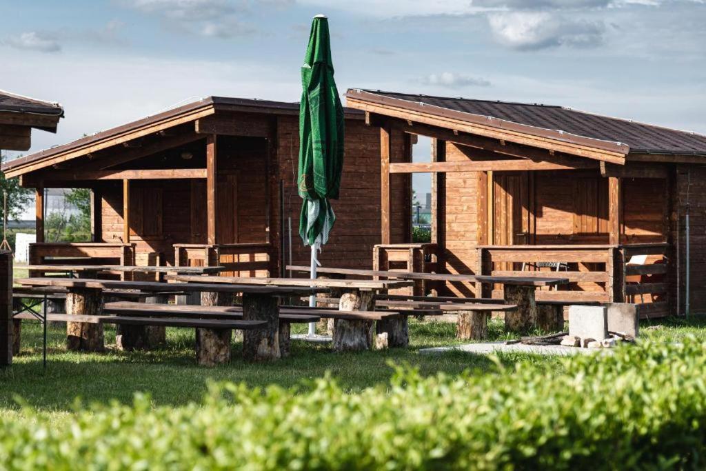布拉迪斯拉发Camping Divoká Voda的一座带绿伞和野餐桌的木制建筑