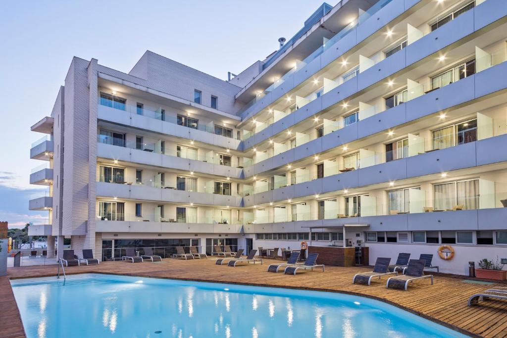 科马鲁加Hotel Balneario Playa de Comarruga的大楼前设有游泳池的酒店