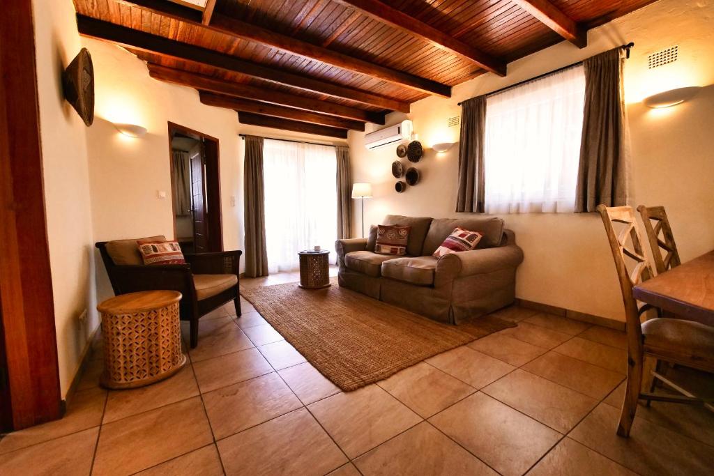 卢萨卡Leopards Hill Lodge的客厅配有沙发和桌子
