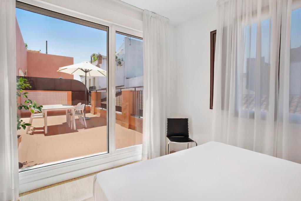 塞维利亚Apartamentos Metrópolis的一间卧室配有一张床,享有庭院的景色