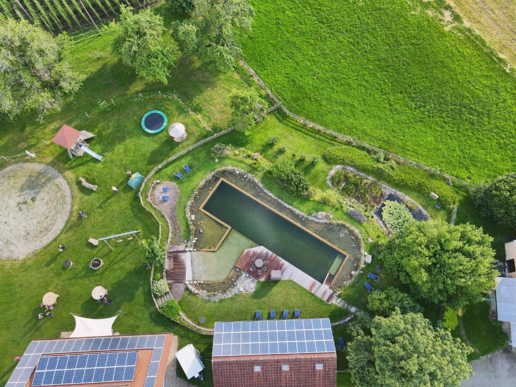 BodneggFerienhof Metzler的享有花园的顶部景致,设有池塘和太阳能电池板