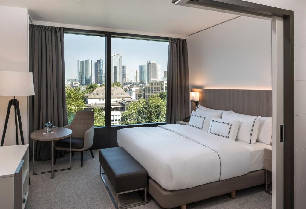 美因河畔法兰克福Meliá Frankfurt City的一间酒店客房,设有一张大床和一个大窗户