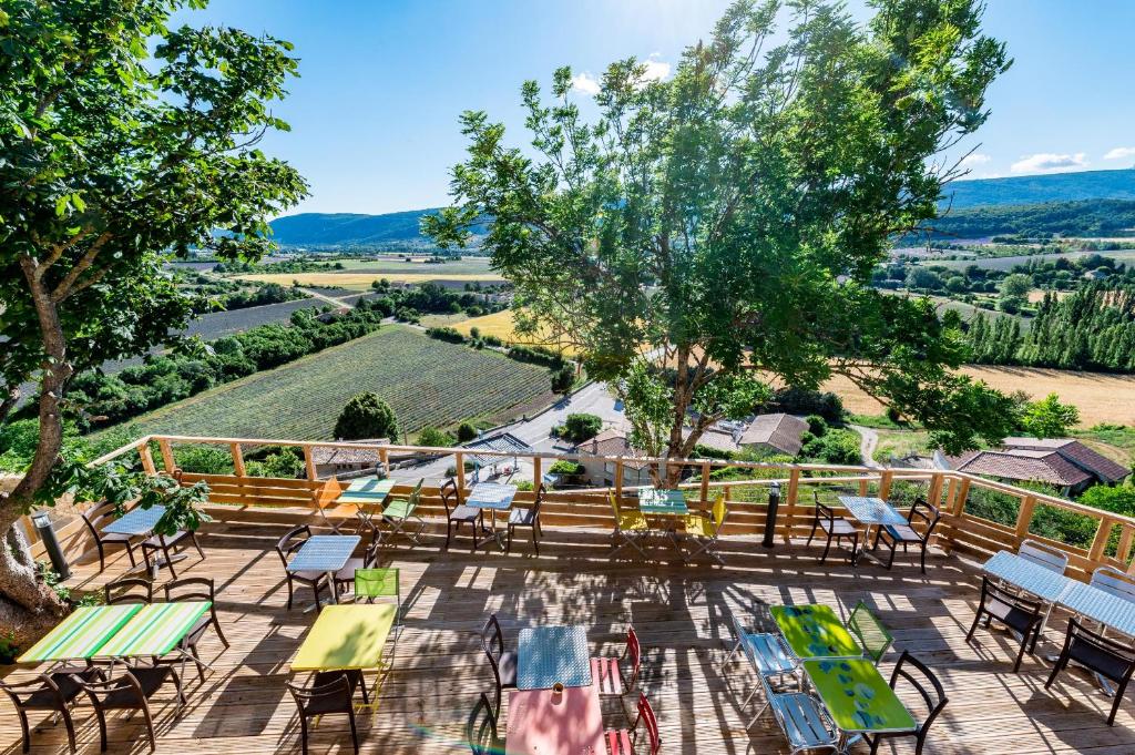 萨路特德沃克吕兹Le Nesk Ventoux - Hotel的户外庭院配有桌椅,享有乡村美景。