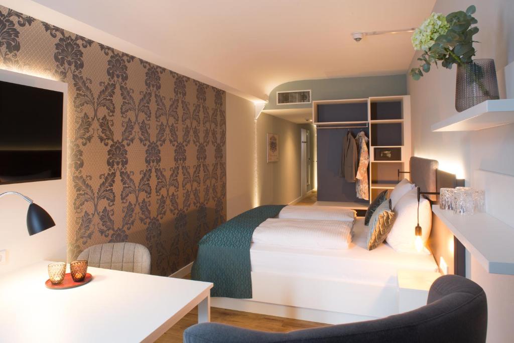 迪尔门Weberei Bendix Hotel & Appartements的酒店客房设有两张床和一张桌子。
