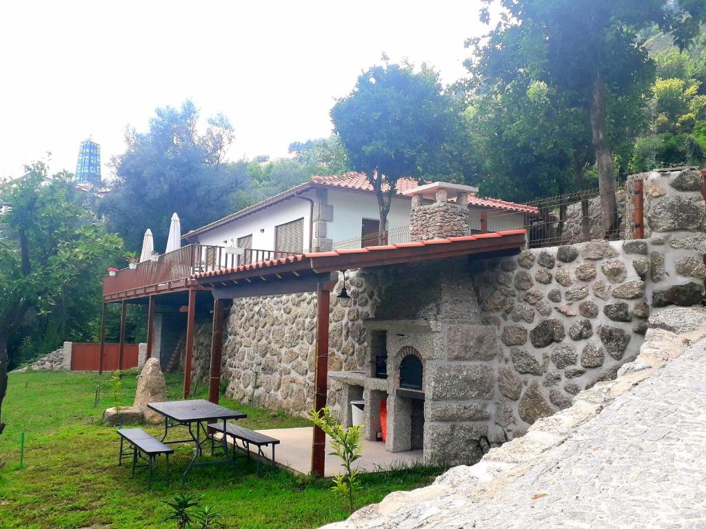 吉尔斯Quinta da Casa Matilde - NATURE HOUSE的石头建筑,上面有桌子和长凳