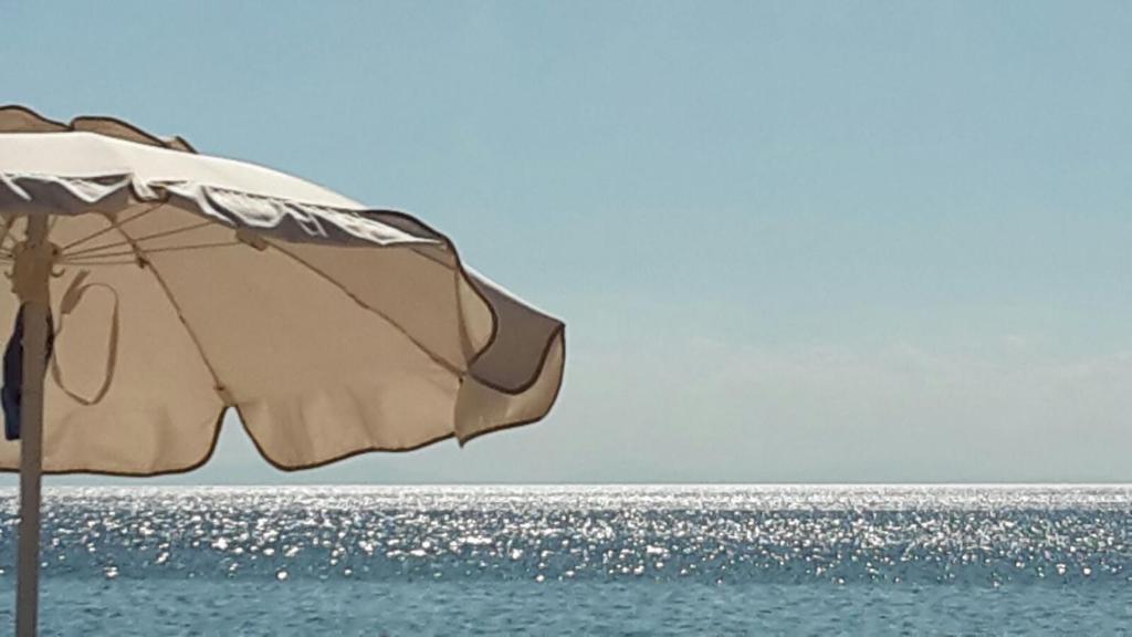 普尔萨诺appartamento VENTO的一把太阳伞,坐在海边