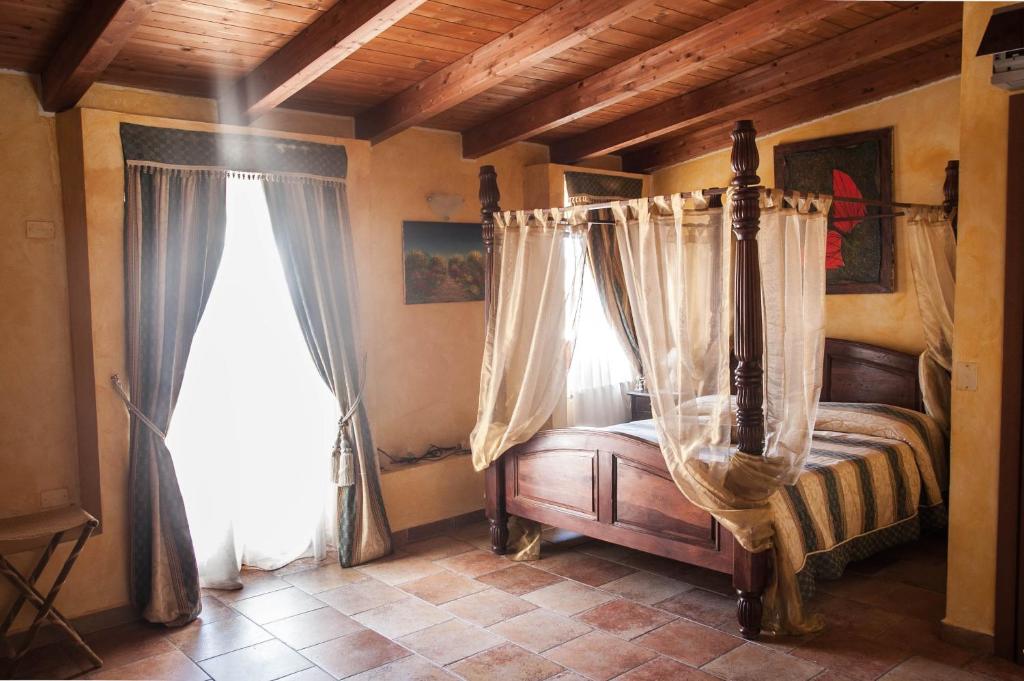 瓦斯托洛坎达狄巴洛尼酒店的一间卧室设有天蓬床和2个窗户