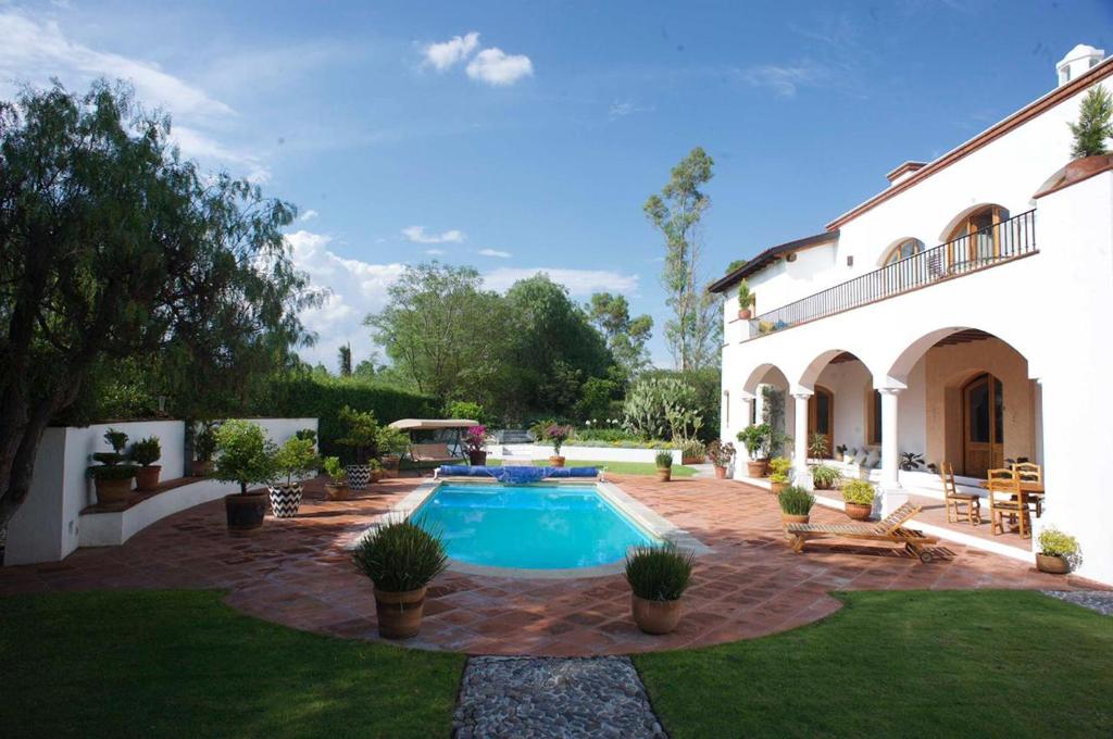 Villa del PueblitoLa Casona de los Colibríes的庭院中带游泳池的房子